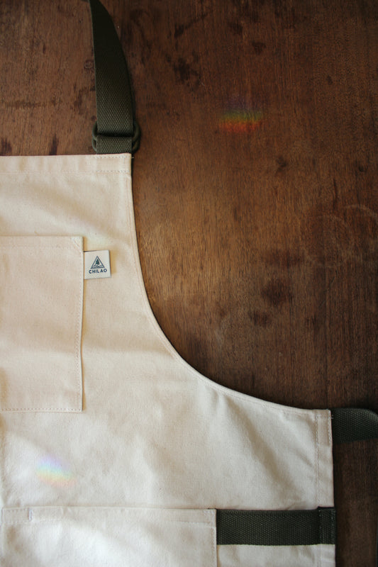 Close-up of Buckhorn Apron natural canvas fabric and brass hardware
