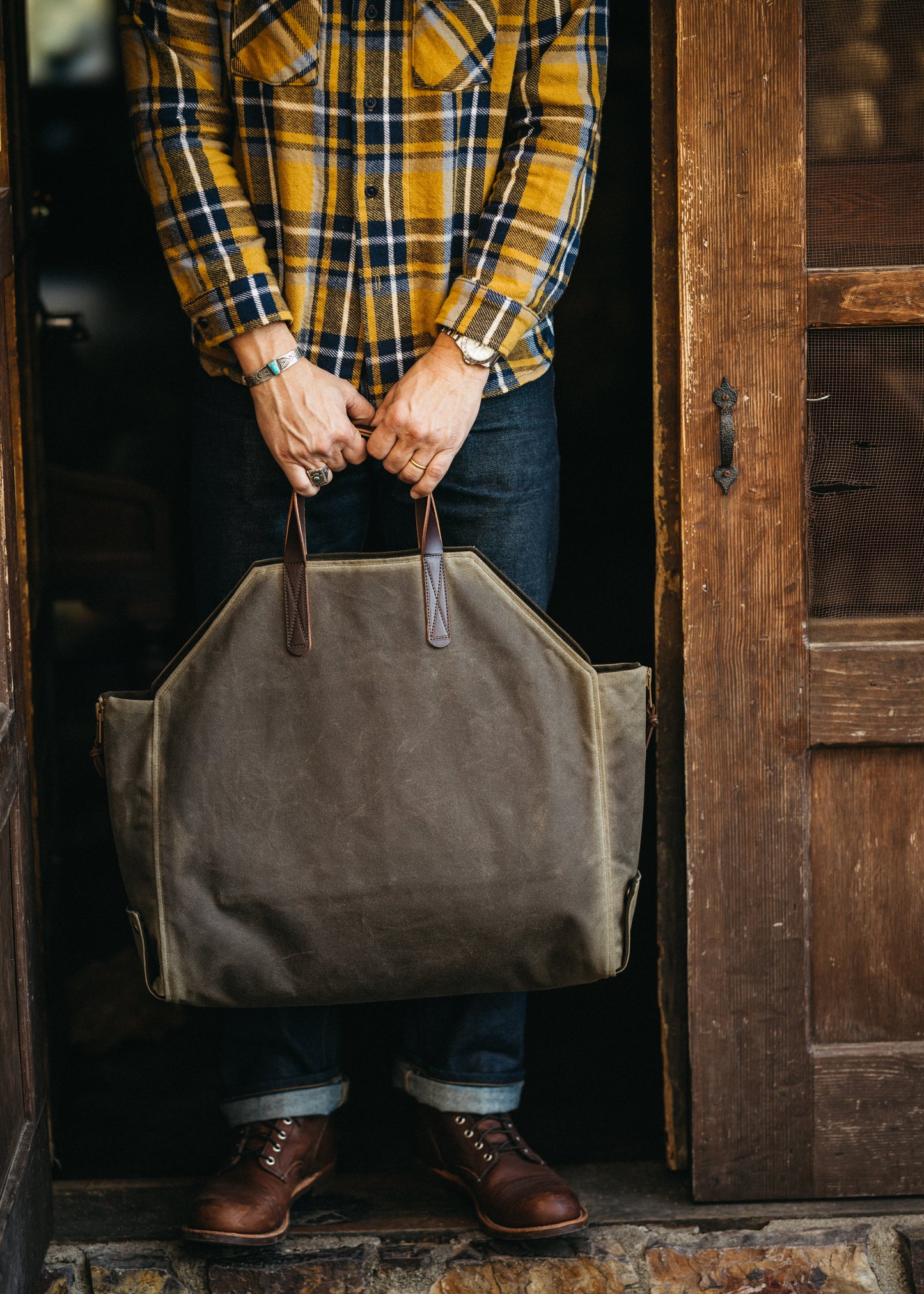 Newcomb tote in a brown waxed canvas exterior, duck canvas interior, and English Bridal leather handles