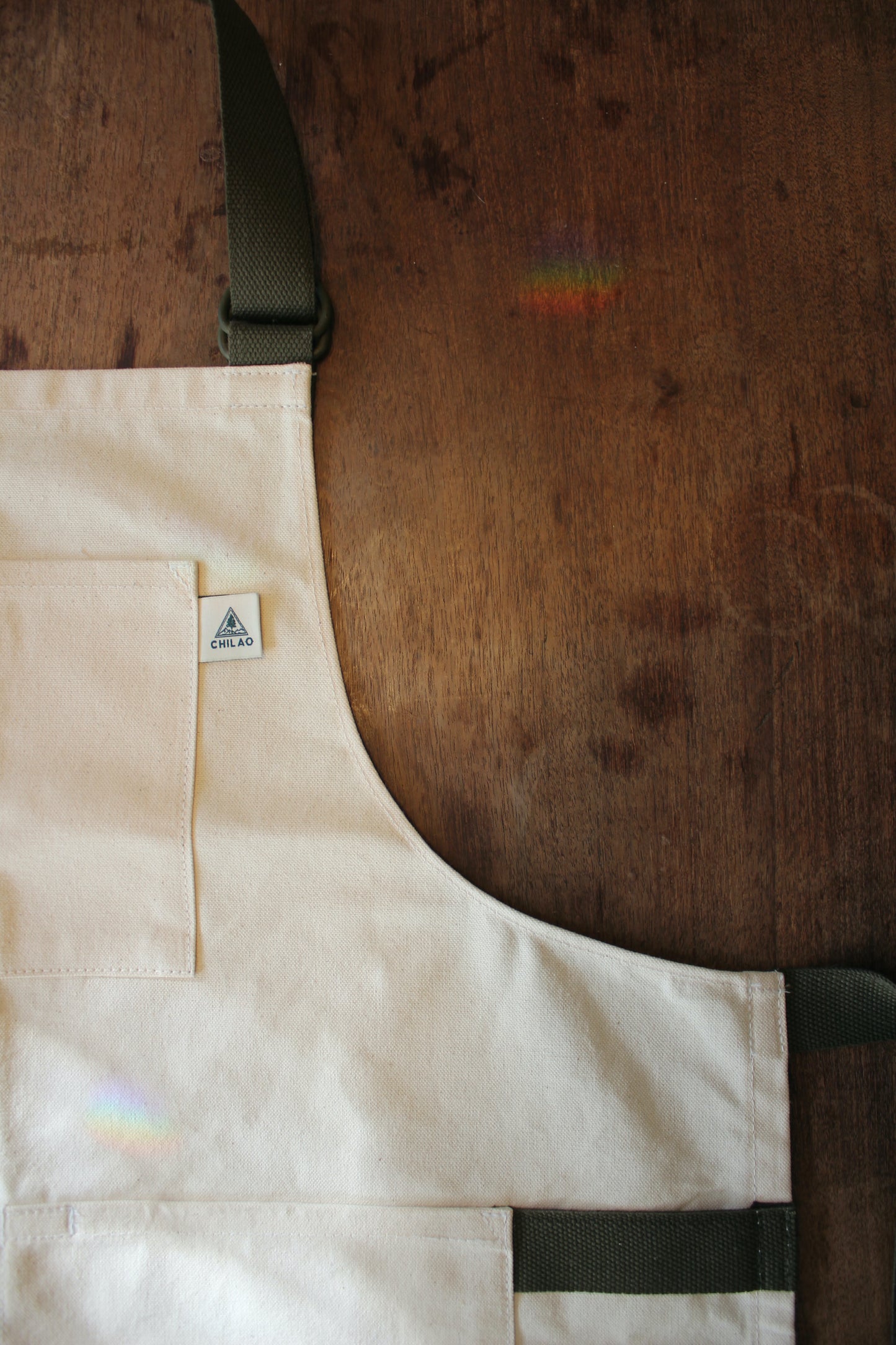 Close-up of Buckhorn Apron natural canvas fabric and brass hardware