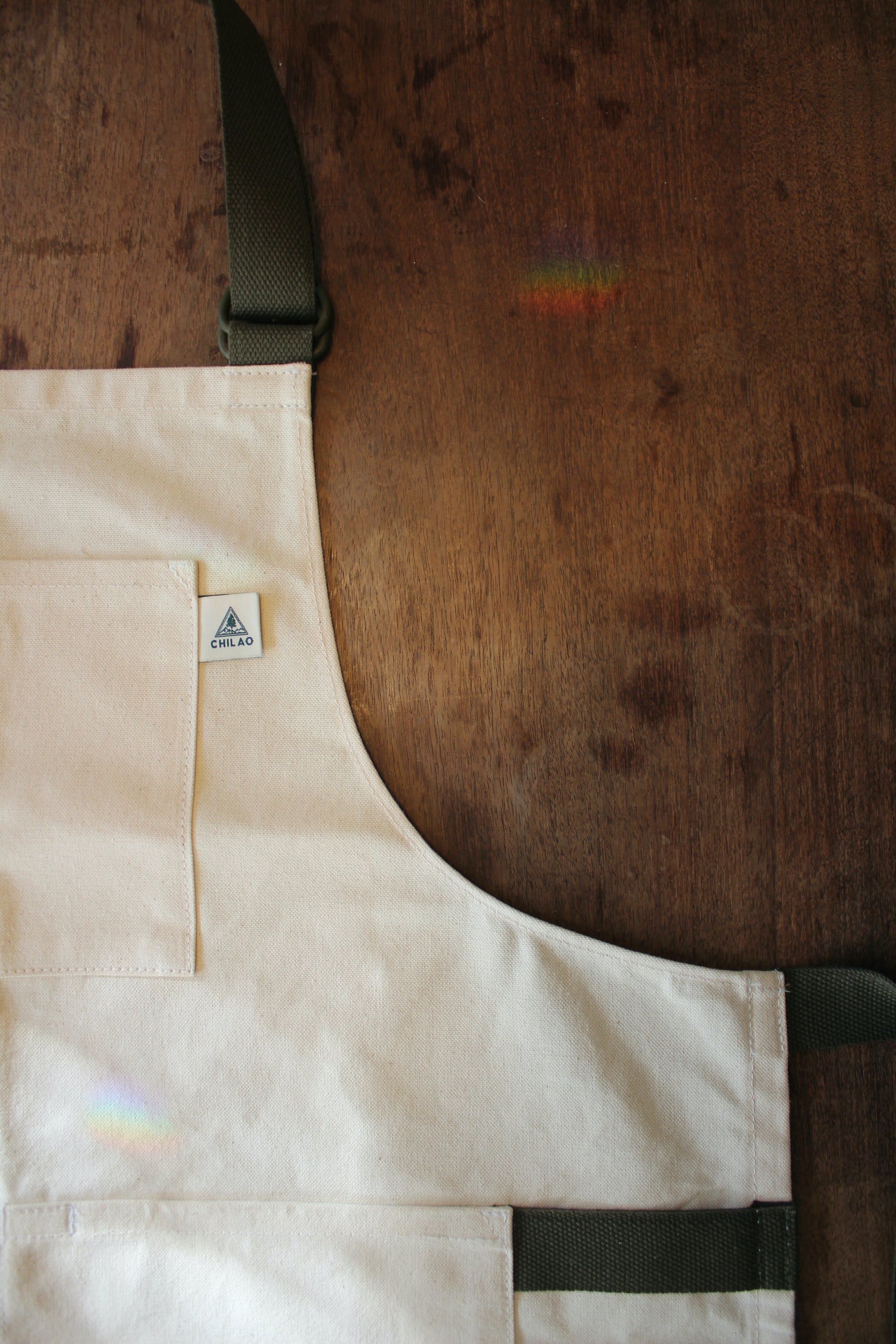 Close-up of Buckhorn Apron natural canvas fabric and brass hardware