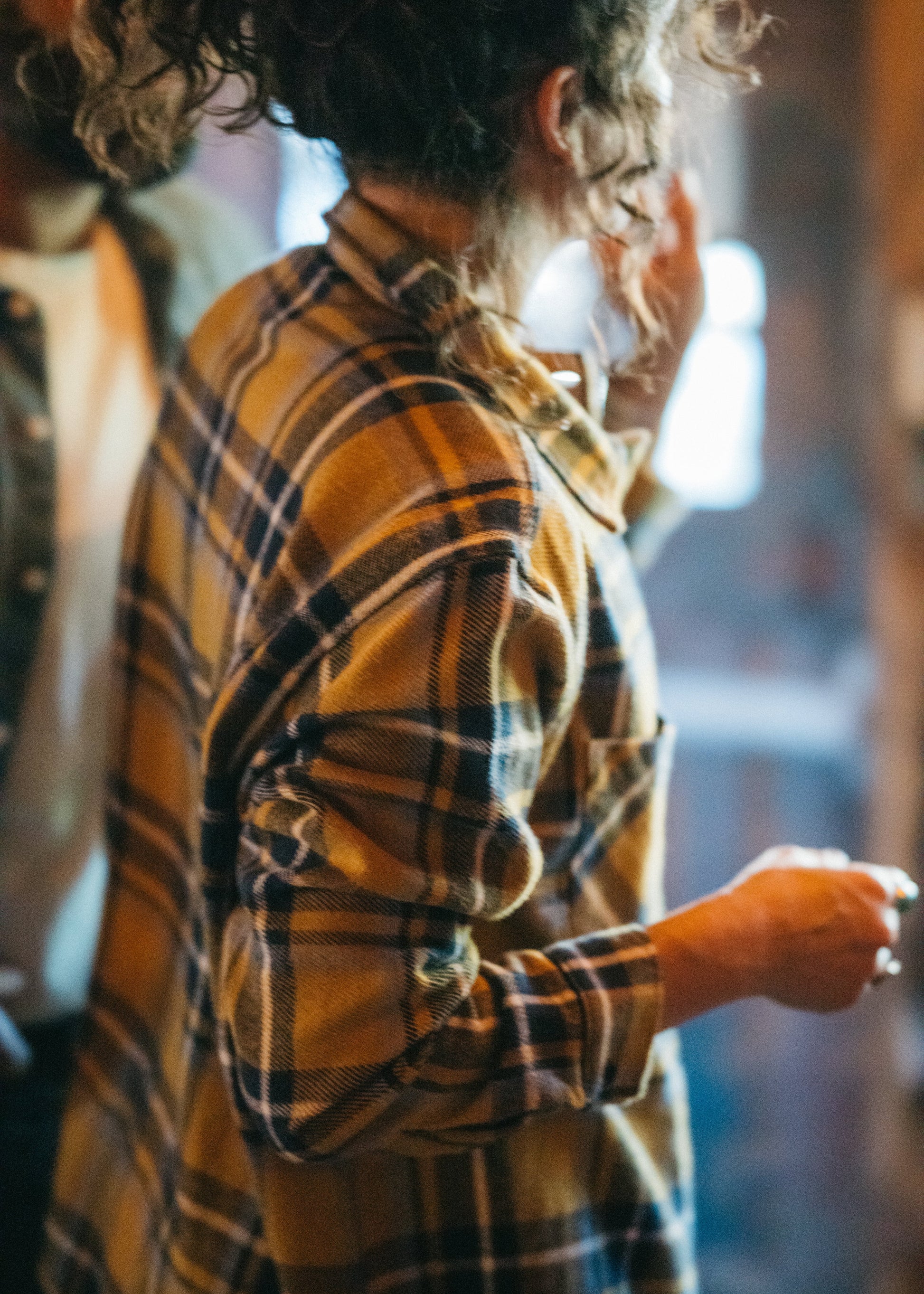 Woman wearing a yellow blue plaid flannel in an indoor setting