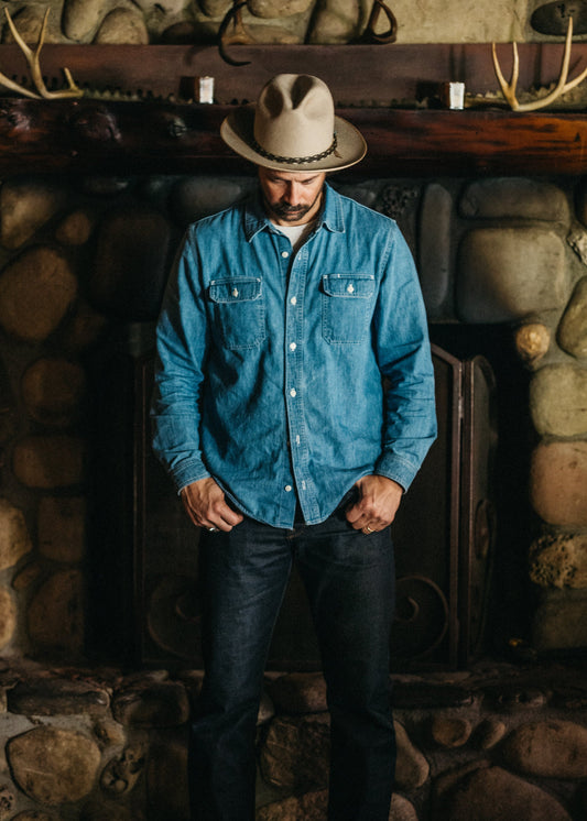 Lone Pine light wash denim shirt - front view showing corozo button detail with fireplace in background