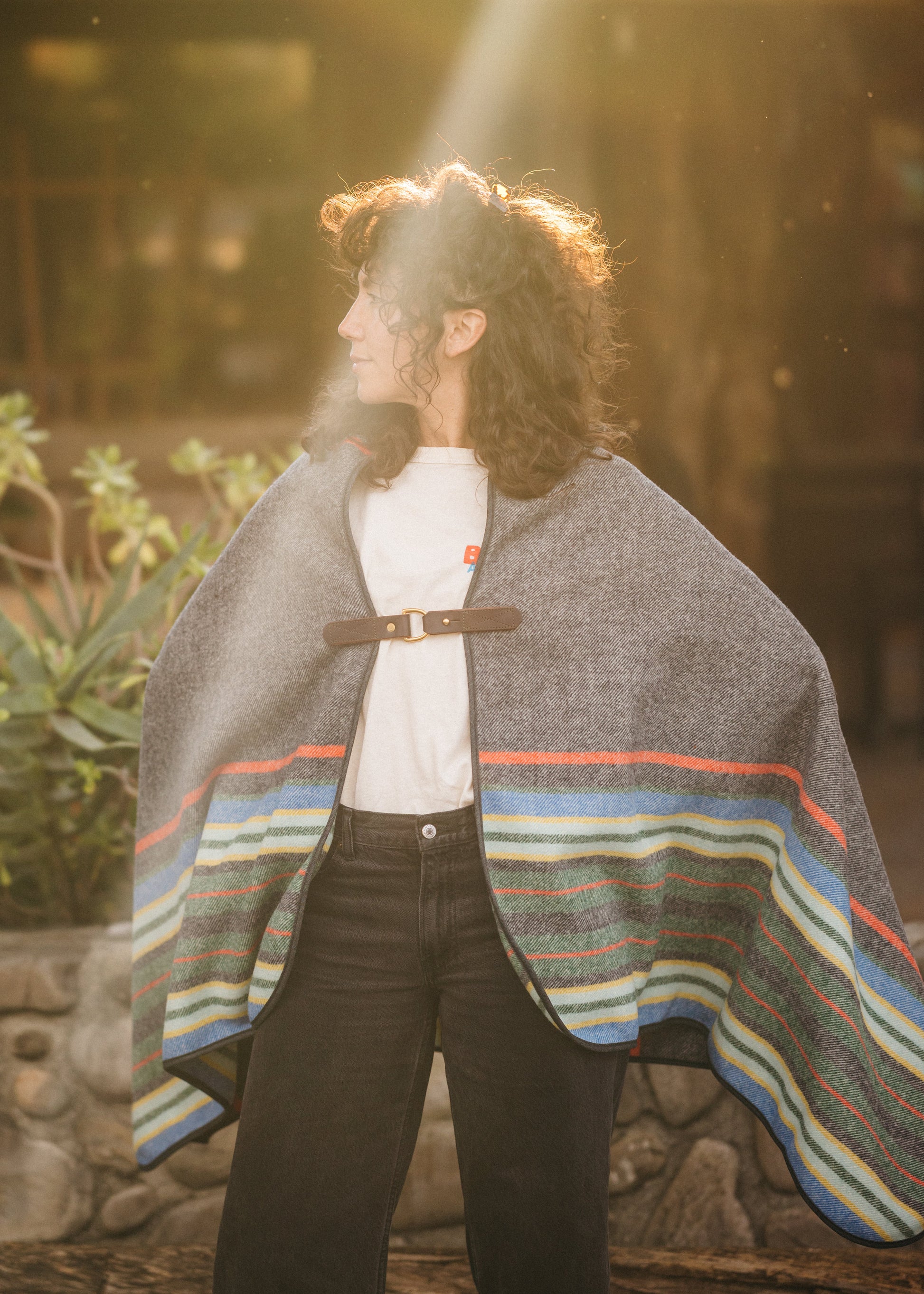 Person wearing a colorful striped poncho in a natural setting