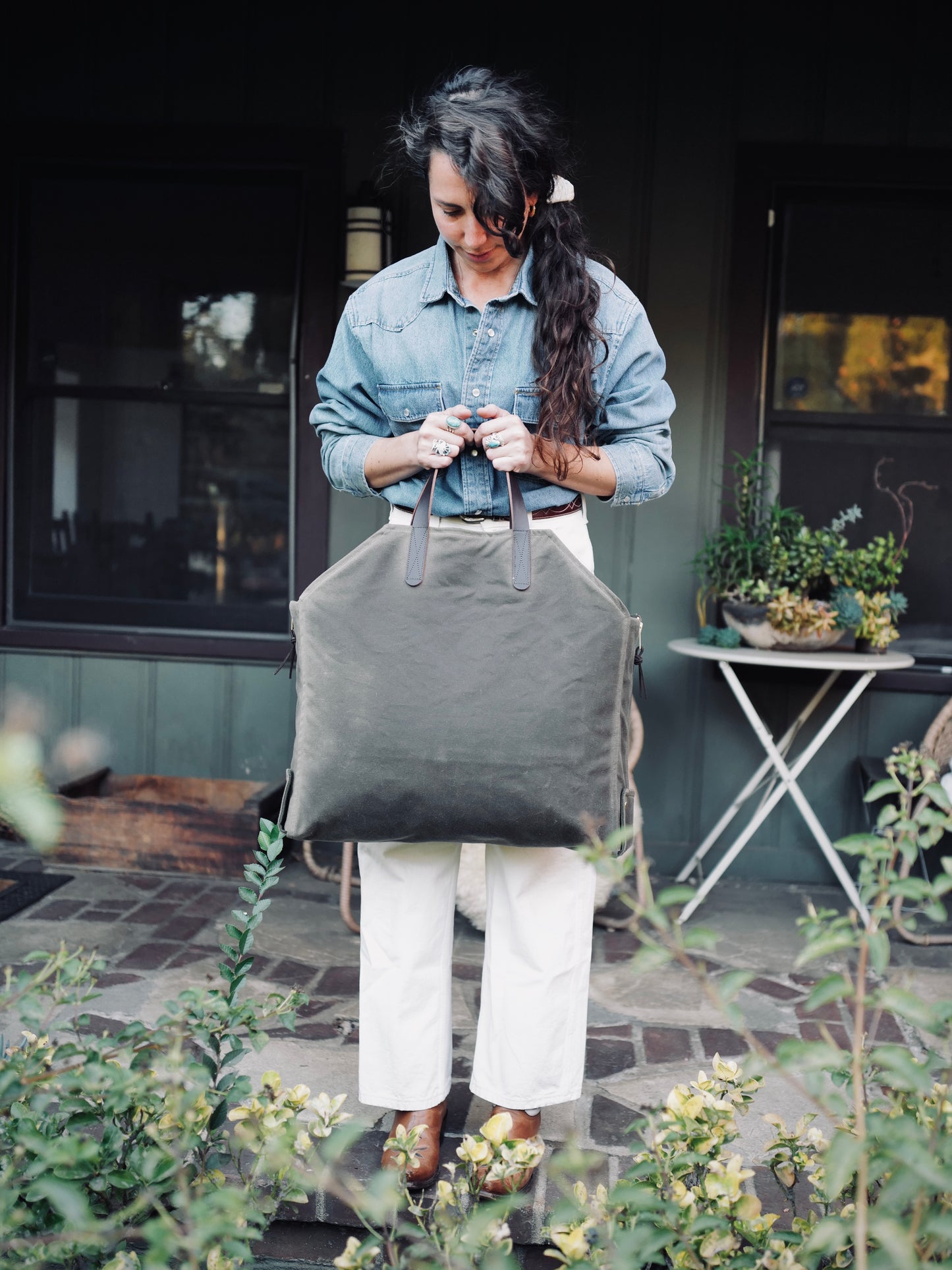 Person carrying Newcomb brown waxed canvas tote